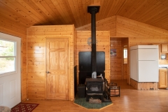 Wood Stove And Kitchen Area At Outpost Cabin
