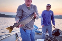 Angler Holding Trout at Sunset on Quiet Lake