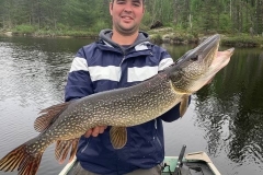 Angler Holding Pike in Misty Morning Light