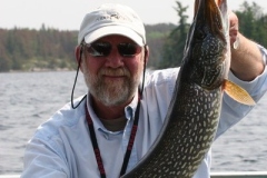 Angler Holding Thick Northern Pike in Calm Water