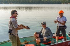 Two Anglers Admiring Pike Beside Shallow Water