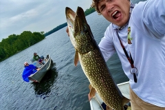 Excited Angler Showing Pike Near Companion Boat