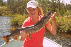 Woman Showing Colorful Pike Beside Reeds